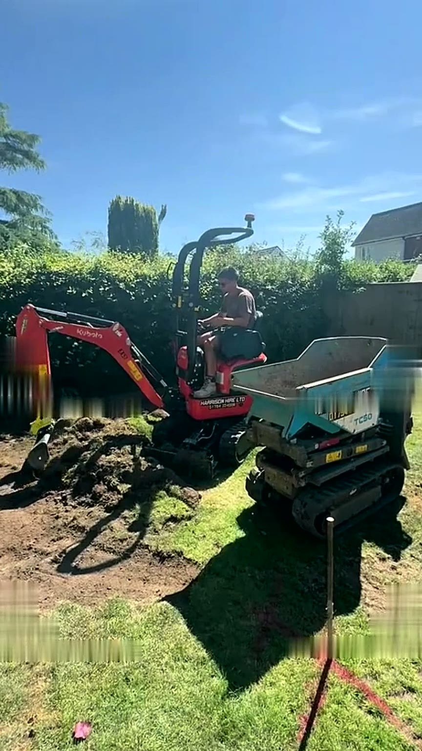 Compact excavator stripping turf from a rear garden during preparation