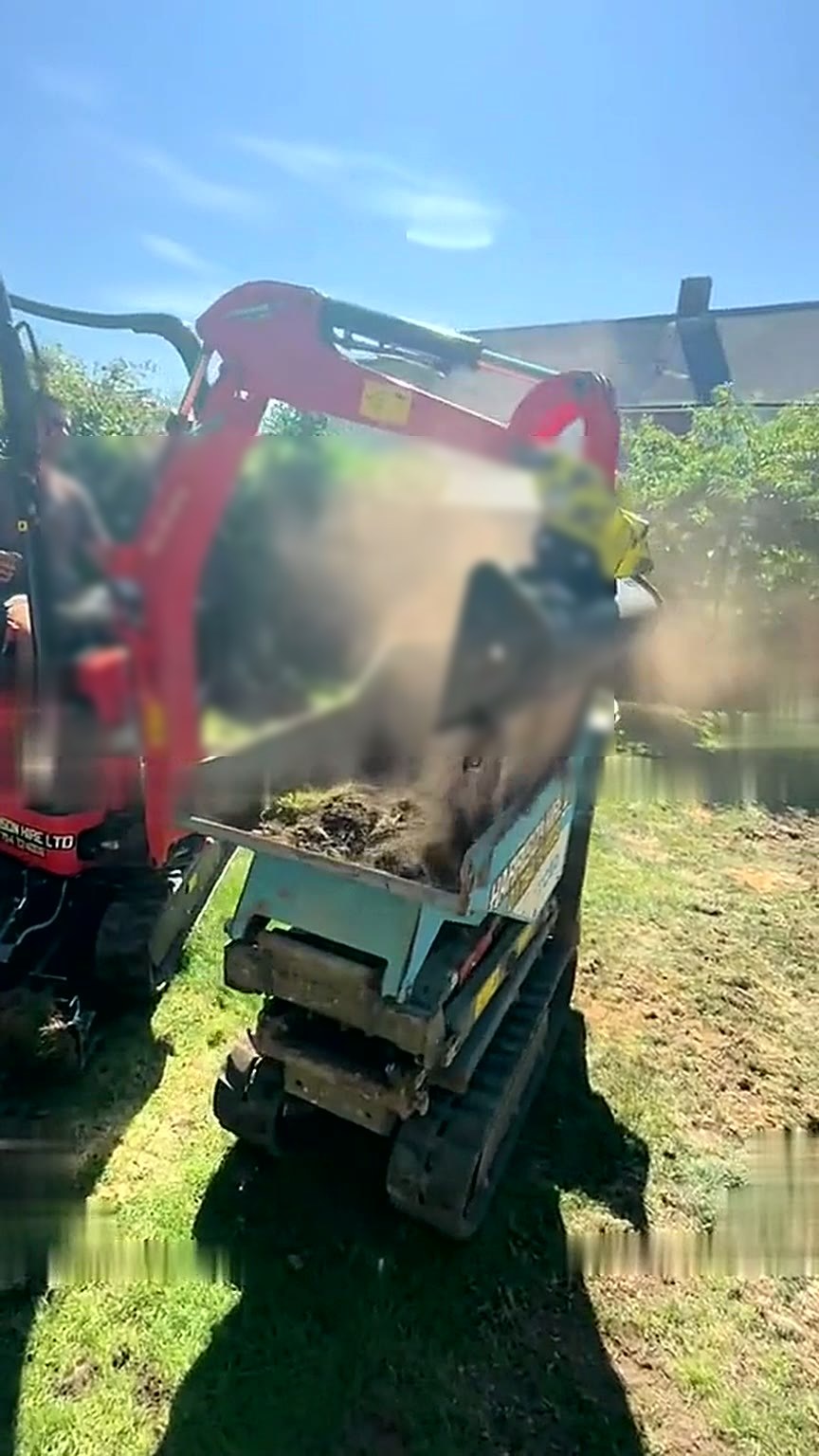 Tracked dumper removing spoil from a garden through a narrow side access