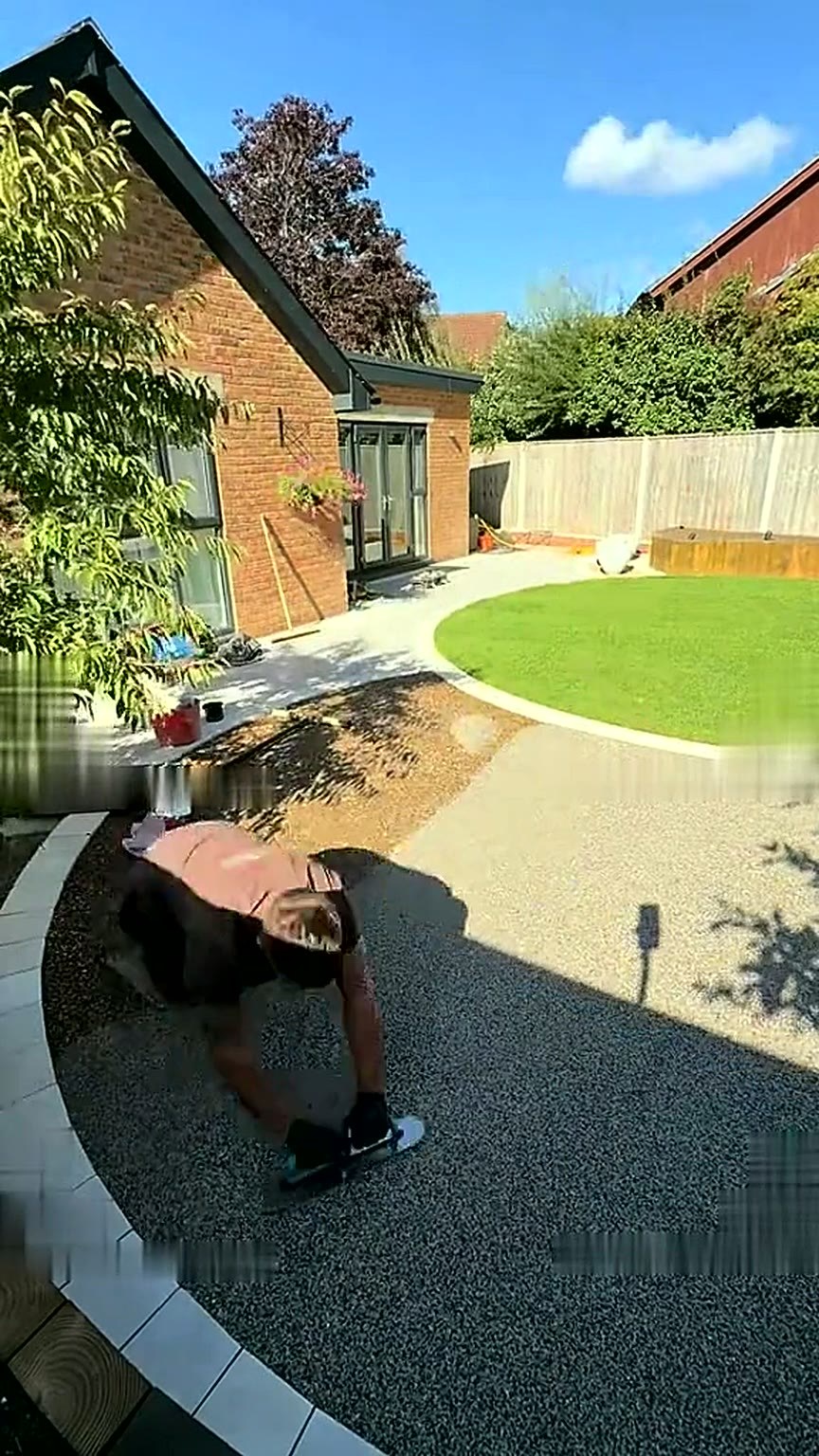 Resin garden surface being finished around a new circular lawn behind a bungalow