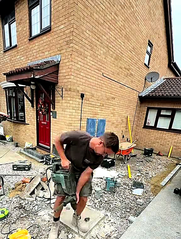 Installer preparing the sub-base and levels across a front driveway