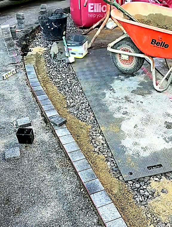 Charcoal block paving border laid with a pale contrast course along a driveway edge