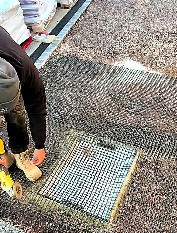 Recessed tray manhole cover set flush into a prepared driveway surface