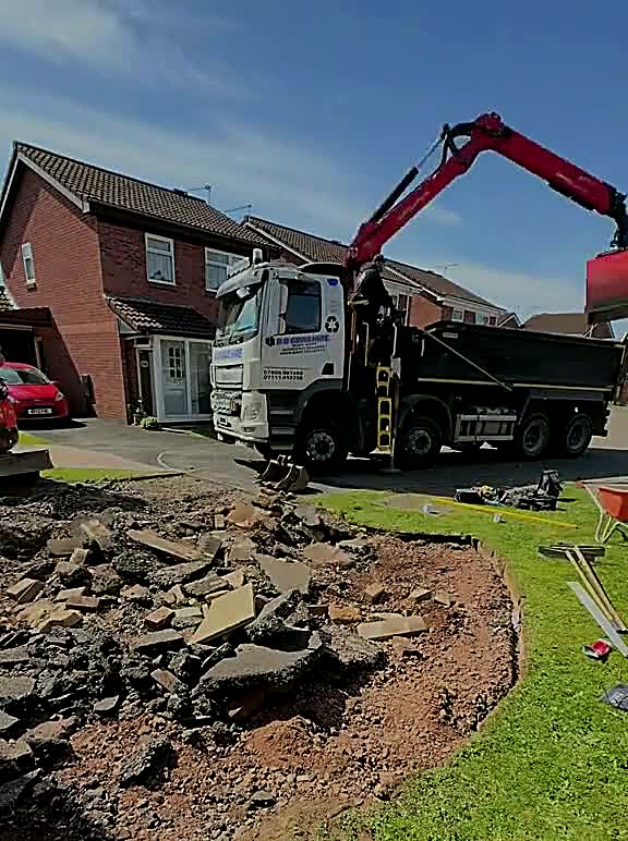 Cracked tarmac driveway broken out in front of a red-brick Carlisle house