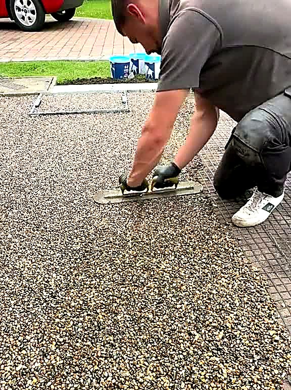 Installer hand-trowelling resin bound surface smooth