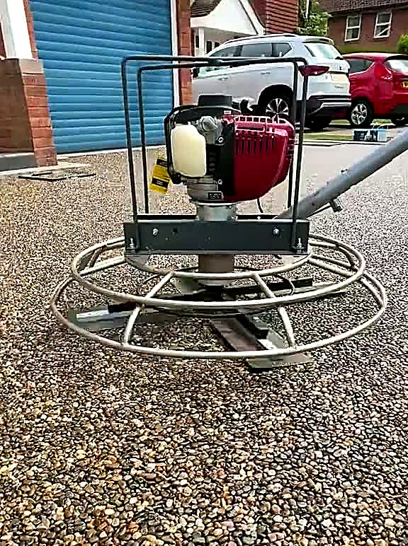 Power float machine standing on a freshly laid resin driveway