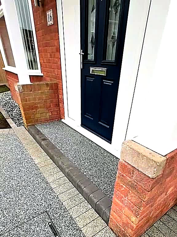 Golden resin path meeting granite setts at a navy front door