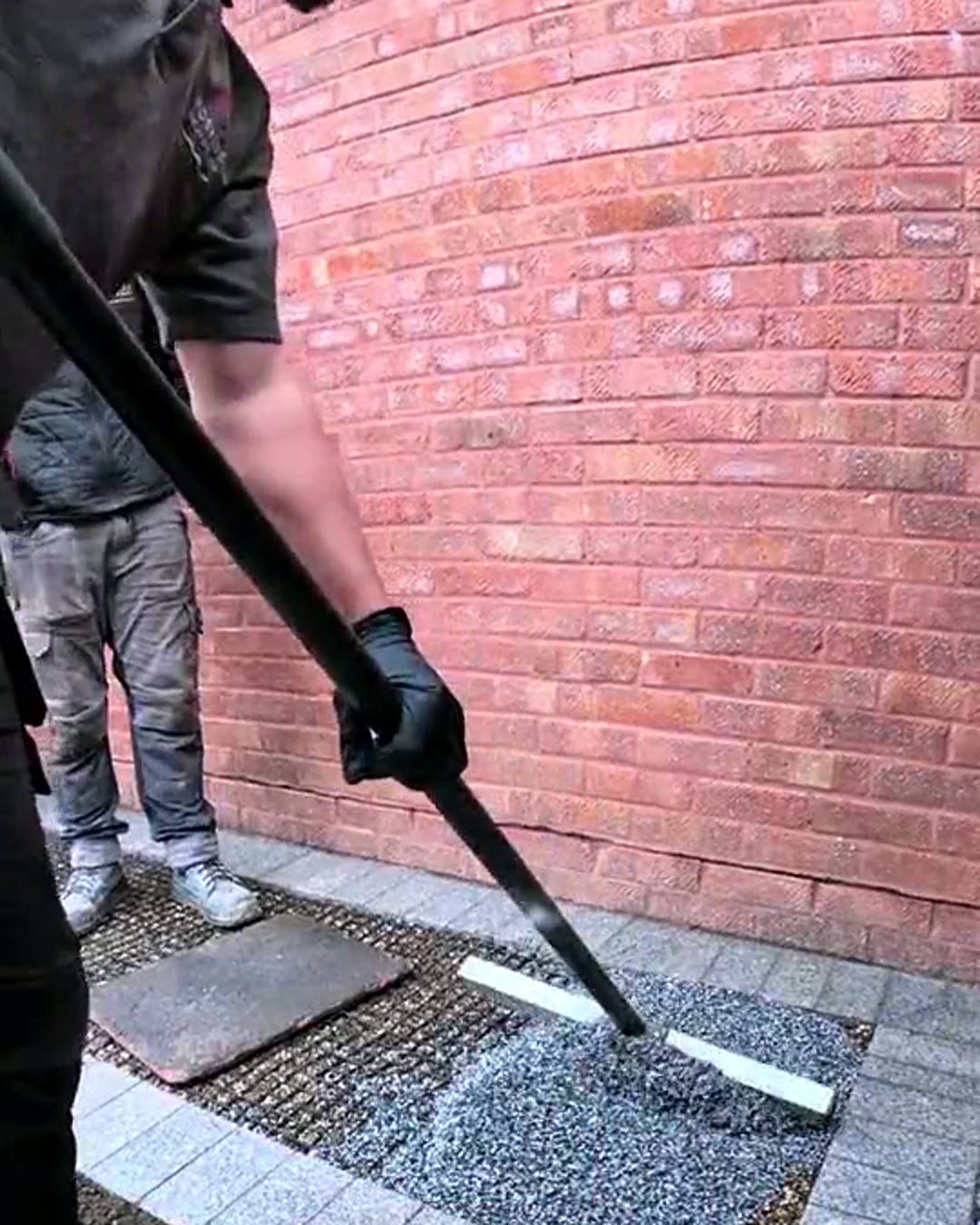 Resin surface being hand-finished against a brick wall edge