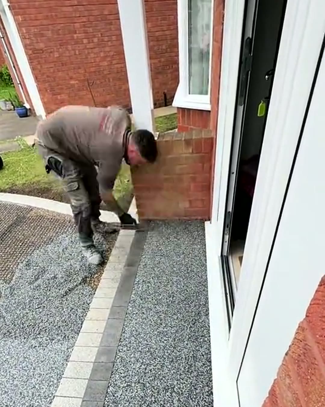 Installer screeding resin bound aggregate up to a front door threshold