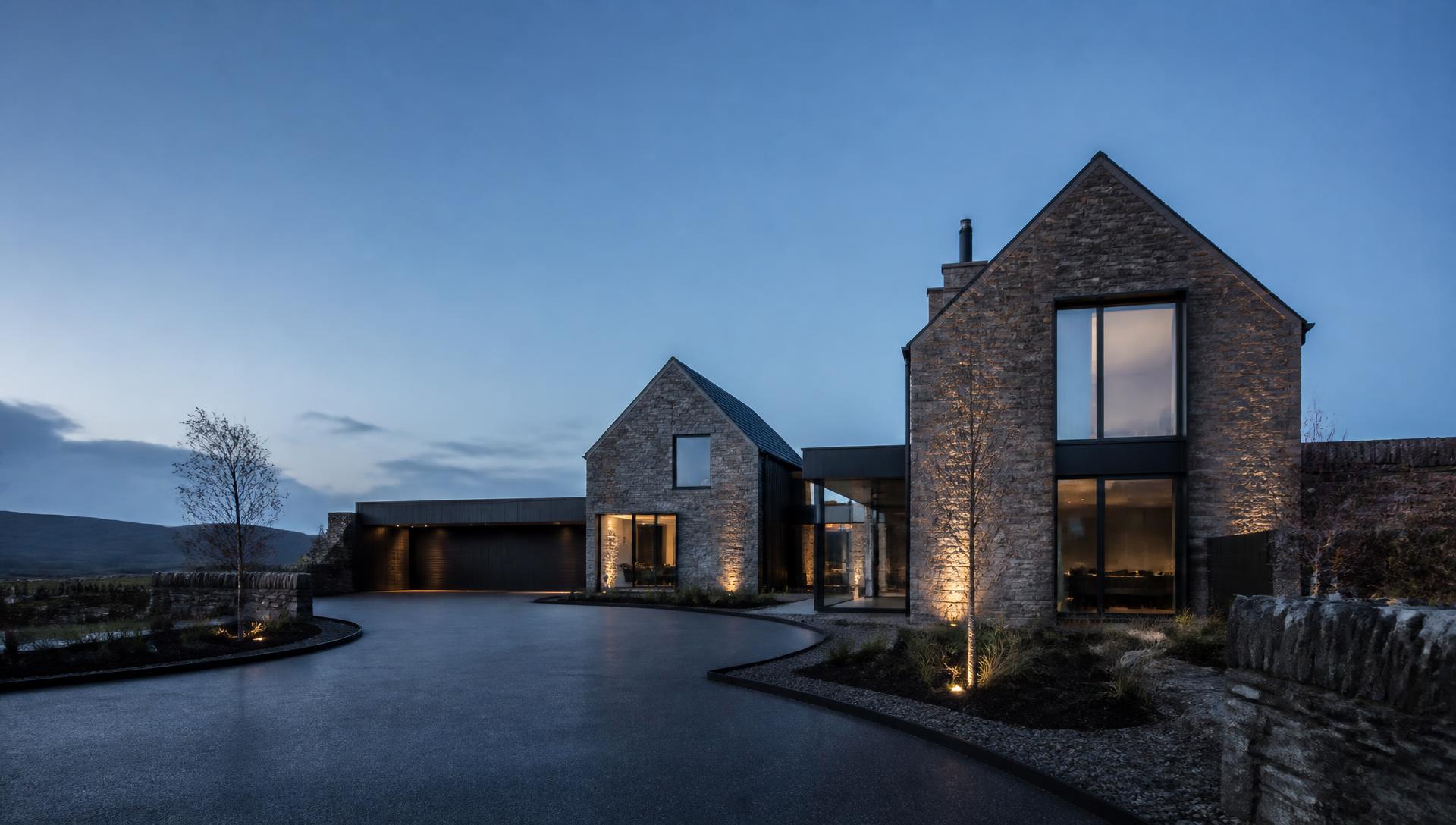 Contemporary Cumbrian stone home with a resin driveway at blue hour
