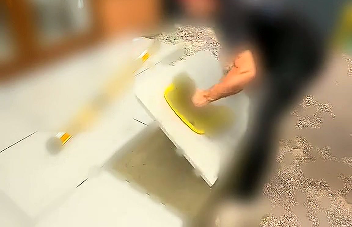 Porcelain slab being lowered onto the mortar bed