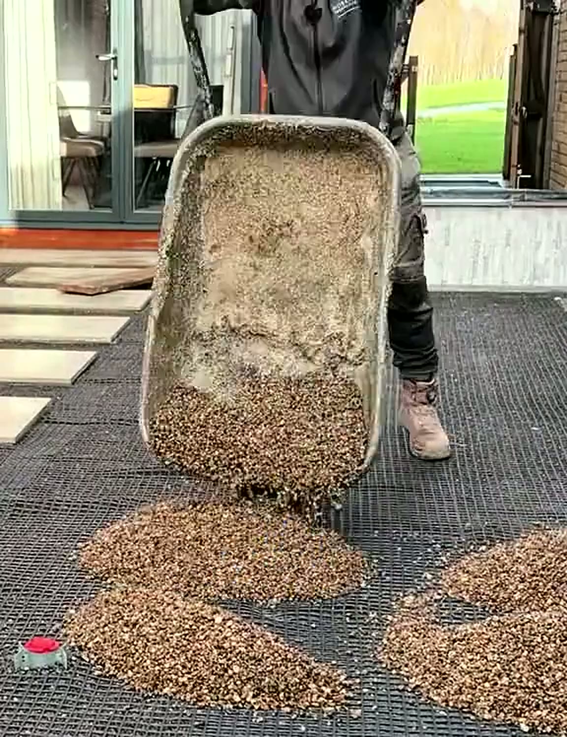 Barrow of resin bound aggregate being tipped onto the prepared base
