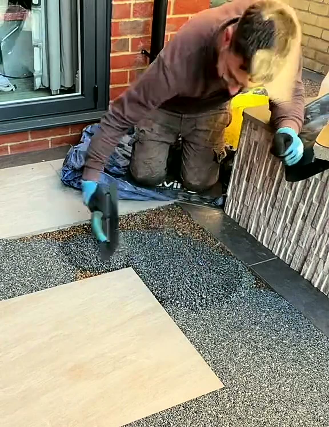 Installer cleaning back a porcelain slab set into a new resin path