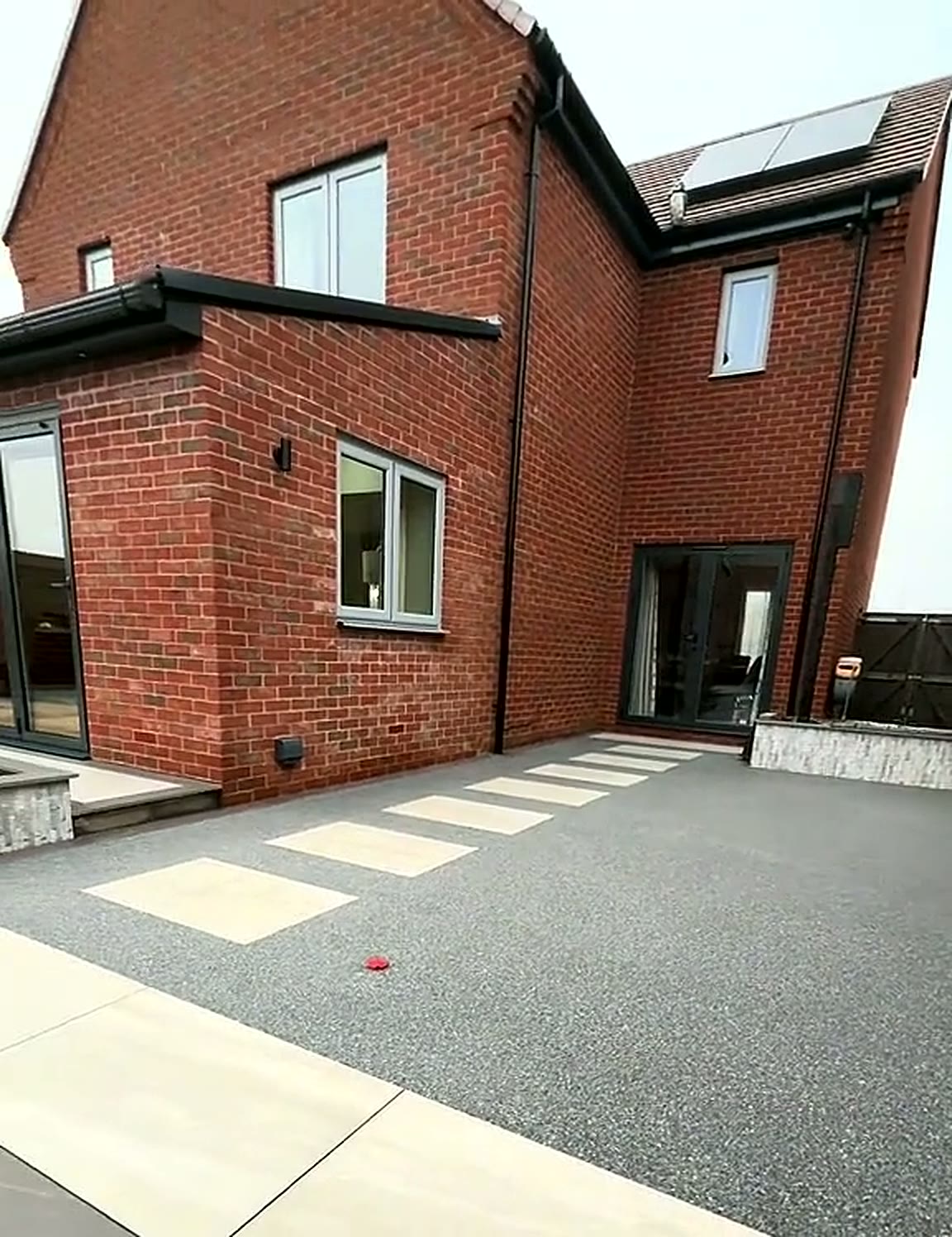 Completed resin garden path with pale porcelain inlay slabs at a rear elevation