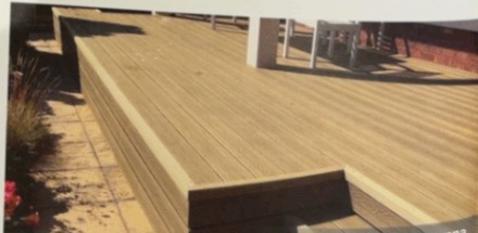 Multi-level composite decking terrace with integrated steps in a Cumbrian garden